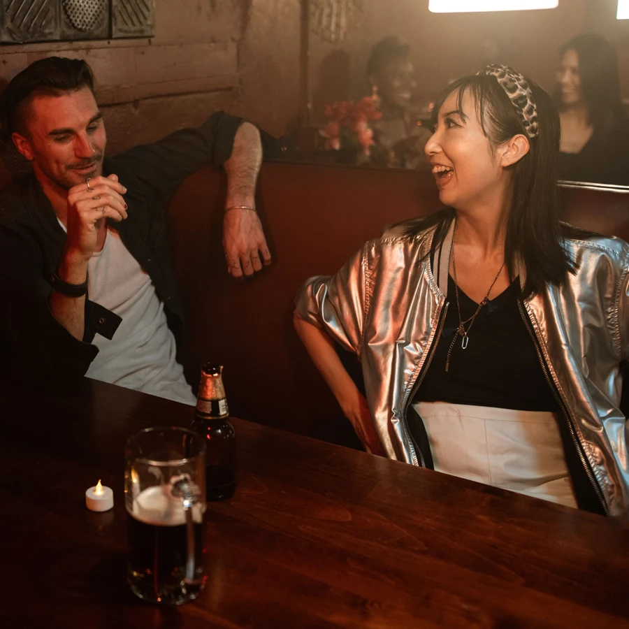 Mara and her match laughing together at a bar in Austin